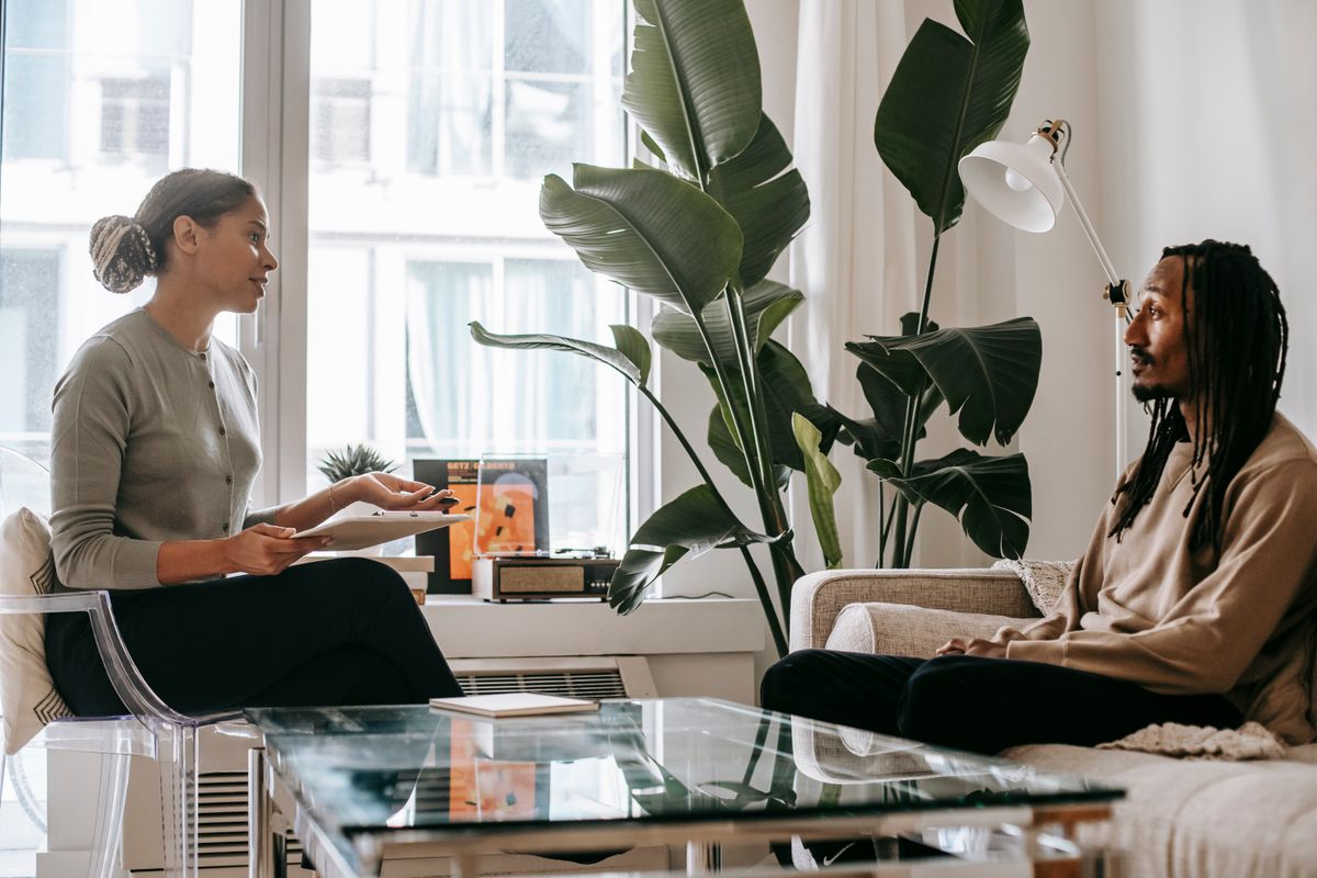 Counselor listening thoughtfully to a client in a softly lit office.